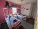 Charming bedroom featuring two twin beds with character-themed bedding and pink walls at 723 Tuscan Hills Blvd, Davenport, FL 33897