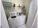 Bright laundry room with appliances, storage shelves, and white tile flooring at 723 Tuscan Hills Blvd, Davenport, FL 33897