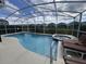 Sparkling pool and jacuzzi with a screened enclosure and lounge chairs for relaxation at 723 Tuscan Hills Blvd, Davenport, FL 33897