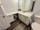 Bathroom featuring a white vanity, wood floors, a large mirror, and a toilet at 7860 Kensingham Ct, Orlando, FL 32835