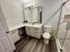 Bathroom featuring a white vanity, wood floors, a large mirror, and a toilet at 7860 Kensingham Ct, Orlando, FL 32835