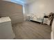 Bedroom featuring gray wood floors, a white crib, and a changing table at 7860 Kensingham Ct, Orlando, FL 32835