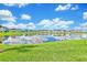 Scenic view of colorful homes reflected in a peaceful community lake under a bright, cloudy sky at 8165 Surf St, Kissimmee, FL 34747