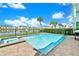 Private pool and hot tub overlooking a serene pond, surrounded by lush landscaping and colorful neighborhood homes at 8165 Surf St, Kissimmee, FL 34747