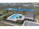 Aerial view showcasing the community pool, clubhouse, adjacent lake with fountain and manicured landscaping at 9009 Pinales Way, Kissimmee, FL 34747