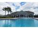 Community pool featuring a splash fountain, shaded lounge area, and inviting blue water on a sunny day at 9009 Pinales Way, Kissimmee, FL 34747