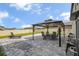 Backyard patio with stone pavers, featuring an outdoor dining area with furniture and a grill at 953 Cambridge Dr, Winter Haven, FL 33881