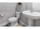 Simple bathroom featuring a toilet and pedestal sink with neutral tile flooring and light gray walls at 953 Cambridge Dr, Winter Haven, FL 33881