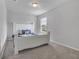 Cozy bedroom with plush carpeting, a white bed frame with floral bedding, and a bright window view at 953 Cambridge Dr, Winter Haven, FL 33881