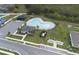 Aerial shot showcasing a community pool with lounging area, parking, and clubhouse among green spaces at 953 Cambridge Dr, Winter Haven, FL 33881