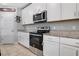 Well-lit kitchen featuring granite countertops, stainless steel oven and microwave, and ample cabinet space at 953 Cambridge Dr, Winter Haven, FL 33881