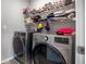 Modern laundry room with stainless steel washer and dryer and shelving for storage and organization at 953 Cambridge Dr, Winter Haven, FL 33881