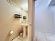 Cozy powder room featuring pedestal sink and floral wallpaper border at 10409 Laxton St, Orlando, FL 32824