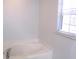 Bright bathroom with a soaking tub under a window with blinds at 10409 Laxton St, Orlando, FL 32824