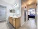 Well-lit bathroom with double sinks, a shower, and an archway leading to the Primary bedroom at 10409 Laxton St, Orlando, FL 32824