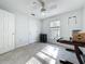 Well-lit bedroom showcasing neutral walls, tile flooring, ceiling fan and a window offering outside views at 10409 Laxton St, Orlando, FL 32824