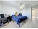 Well-lit bedroom with tile floors, a desk, and a large bed with a blue comforter at 10409 Laxton St, Orlando, FL 32824