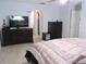 Bright bedroom with dresser, TV, and view of arched doorway at 10409 Laxton St, Orlando, FL 32824