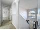 Upstairs hallway with view of staircase, arched window and doorway, and tile flooring at 10409 Laxton St, Orlando, FL 32824