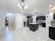 Open concept kitchen with black cabinets, stainless appliances, tile floors and an island with lots of space at 10409 Laxton St, Orlando, FL 32824