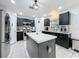 Modern kitchen featuring black cabinets, stainless steel appliances, tile floors and a center island at 10409 Laxton St, Orlando, FL 32824