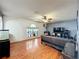 A living room showcases sleek wood floors, a ceiling fan, and a large window at 10409 Laxton St, Orlando, FL 32824