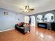 A living room features wood floors, a ceiling fan, arches, and a couch at 10409 Laxton St, Orlando, FL 32824