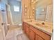 Cozy bathroom featuring double sinks, a tub with shower, and striped wallpaper at 106 Southern Pine Way, Davenport, FL 33837