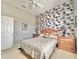 Bedroom featuring a statement wall, a window, a ceiling fan, and two wooden nightstands at 106 Southern Pine Way, Davenport, FL 33837