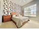 Bright bedroom featuring a window, a ceiling fan, and two wooden nightstands at 106 Southern Pine Way, Davenport, FL 33837