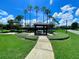 A park with a covered picnic pavilion, lush green grass, manicured landscaping, and beautiful palm trees at 106 Southern Pine Way, Davenport, FL 33837