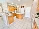 Bright kitchen with white appliances, an island, and tile flooring, offering ample counter space at 106 Southern Pine Way, Davenport, FL 33837