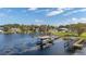 Aerial view of a lakefront community with multiple boat docks, boat lifts, and houses at 10919 Lakeshore Dr, Clermont, FL 34711