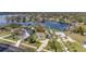 Stunning aerial view of lakeside home, lush landscaping, private dock, and sparkling water at 10919 Lakeshore Dr, Clermont, FL 34711