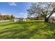 Large, fenced backyard with lush lawn and mature trees on a sunny day at 10919 Lakeshore Dr, Clermont, FL 34711