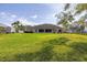 Spacious backyard showcasing the home's exterior, with a well-maintained lawn and screened lanai at 10919 Lakeshore Dr, Clermont, FL 34711