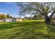 Wide shot of backyard showing a shed, expansive lawn, mature trees, and the home's exterior at 10919 Lakeshore Dr, Clermont, FL 34711