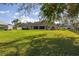 Expansive backyard with lush lawn, view of the home, and mature trees casting shadows at 10919 Lakeshore Dr, Clermont, FL 34711