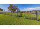 Lawn leads to a waterfront in a beautiful fenced backyard with lake access and dock at 10919 Lakeshore Dr, Clermont, FL 34711