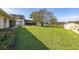 Large, green backyard with a view of the lake, featuring mature trees and a storage shed at 10919 Lakeshore Dr, Clermont, FL 34711