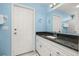 Bathroom with blue walls featuring granite countertops, white cabinets, and modern fixtures at 10919 Lakeshore Dr, Clermont, FL 34711