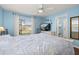 Bright bedroom with light blue walls, hardwood floors, white trim, and a large sunny window at 10919 Lakeshore Dr, Clermont, FL 34711