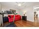 This bedroom with hardwood floors features a treadmill and comfortable red couch at 10919 Lakeshore Dr, Clermont, FL 34711