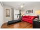 Bedroom with hardwood floors features a treadmill and a comfortable red couch at 10919 Lakeshore Dr, Clermont, FL 34711