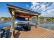 Covered boat dock on a serene lake, featuring boat lift, water, and lakeside community at 10919 Lakeshore Dr, Clermont, FL 34711