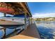 Boat in covered dock with lift, providing lake access to the waterfront property at 10919 Lakeshore Dr, Clermont, FL 34711