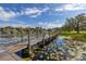 Long dock extends into a picturesque lake, creating a serene setting at 10919 Lakeshore Dr, Clermont, FL 34711