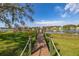 Private wooden dock and lakefront access with lush green surroundings on a sunny day at 10919 Lakeshore Dr, Clermont, FL 34711