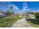 Lovely home with a circular driveway and lush green lawn. Beautiful landscaping at 10919 Lakeshore Dr, Clermont, FL 34711