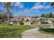 Inviting home featuring a lush green lawn and circular driveway, perfect for Gathering living at 10919 Lakeshore Dr, Clermont, FL 34711